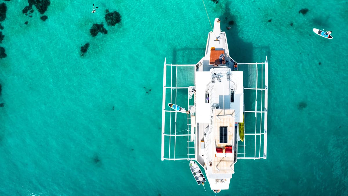 Solar-roofed catamaran anchored in tropical water
