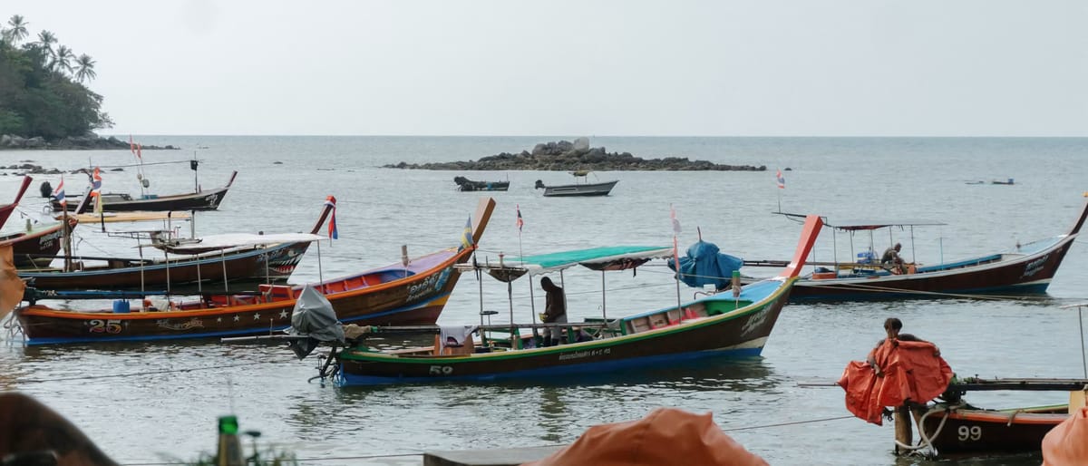 Traditional long-tail boats anchored in clear sea water